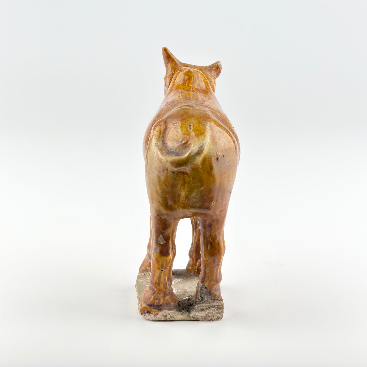 AMBER-GLAZED POTTERY FIGURE OF SACRED BULL, TANG-LIAO DYNASTY (7-12TH CENTURY)