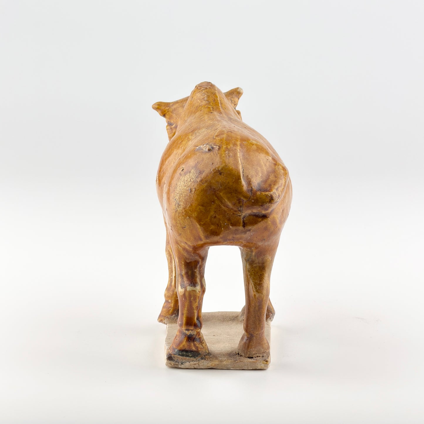 AMBER-GLAZED POTTERY FIGURE OF SACRED BULL, TANG-LIAO DYNASTY (7-12TH CENTURY)