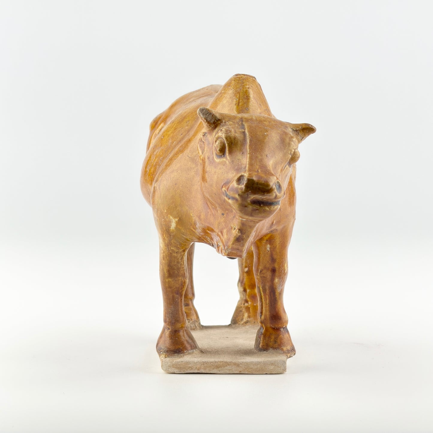 AMBER-GLAZED POTTERY FIGURE OF SACRED BULL, TANG-LIAO DYNASTY (7-12TH CENTURY)