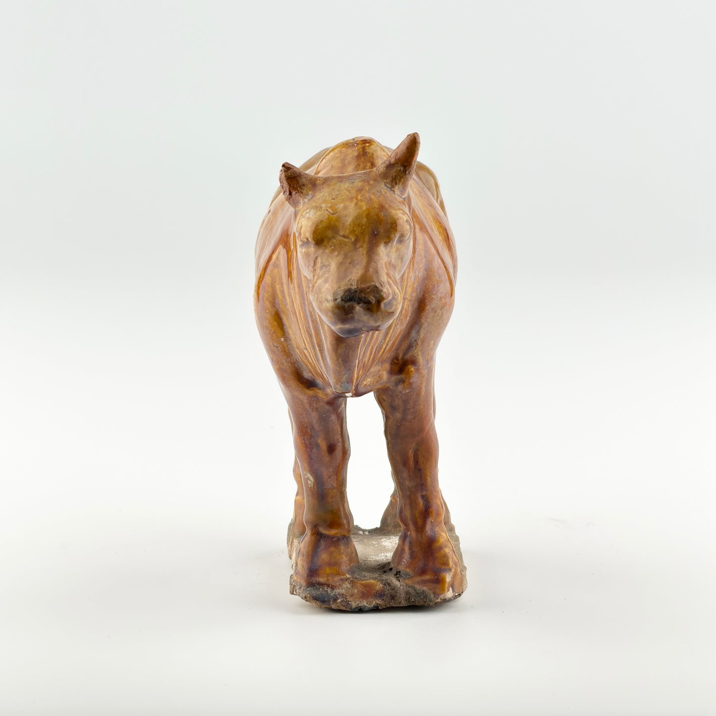 AMBER-GLAZED POTTERY FIGURE OF SACRED BULL, TANG-LIAO DYNASTY (7-12TH CENTURY)