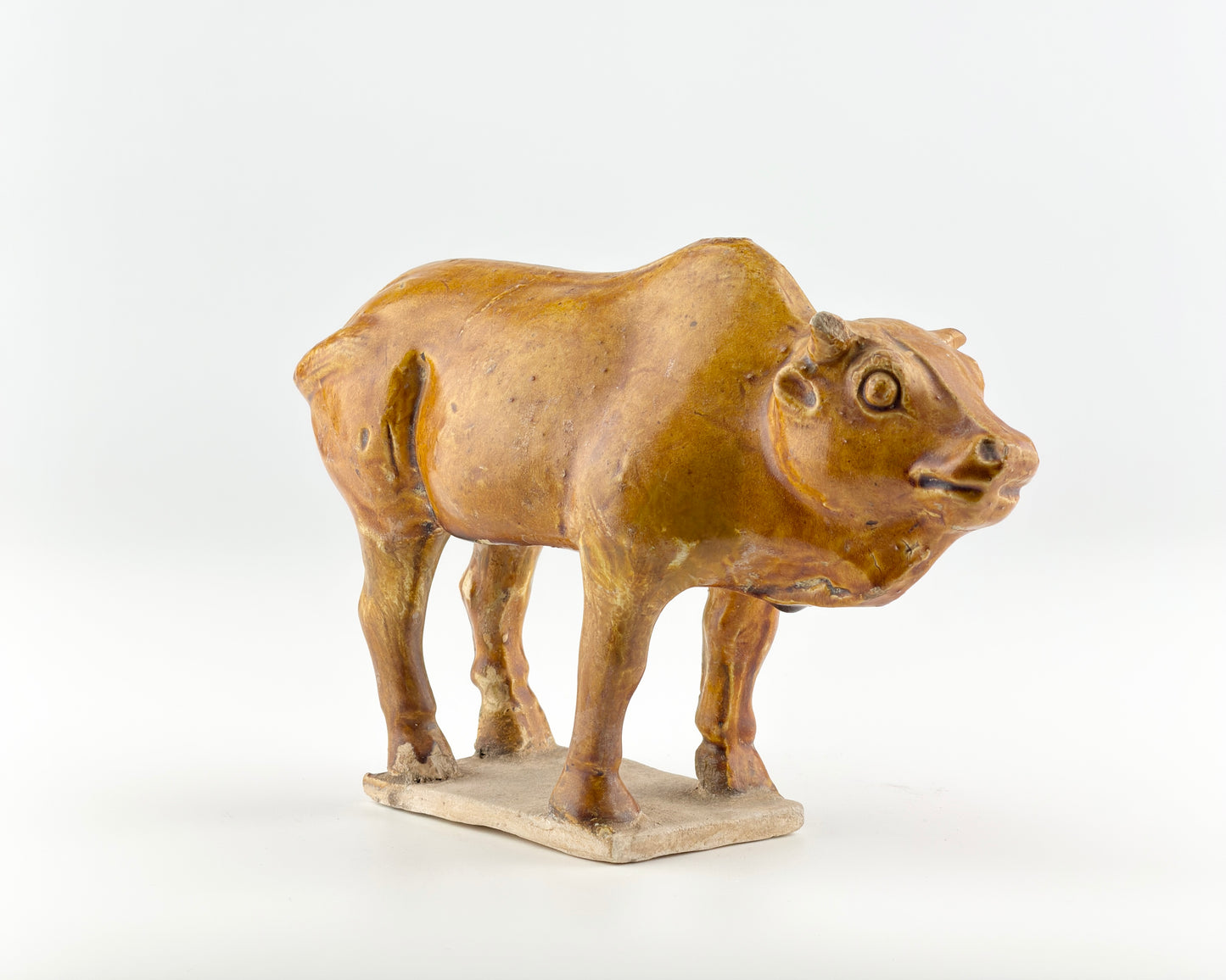 AMBER-GLAZED POTTERY FIGURE OF SACRED BULL, TANG-LIAO DYNASTY (7-12TH CENTURY)