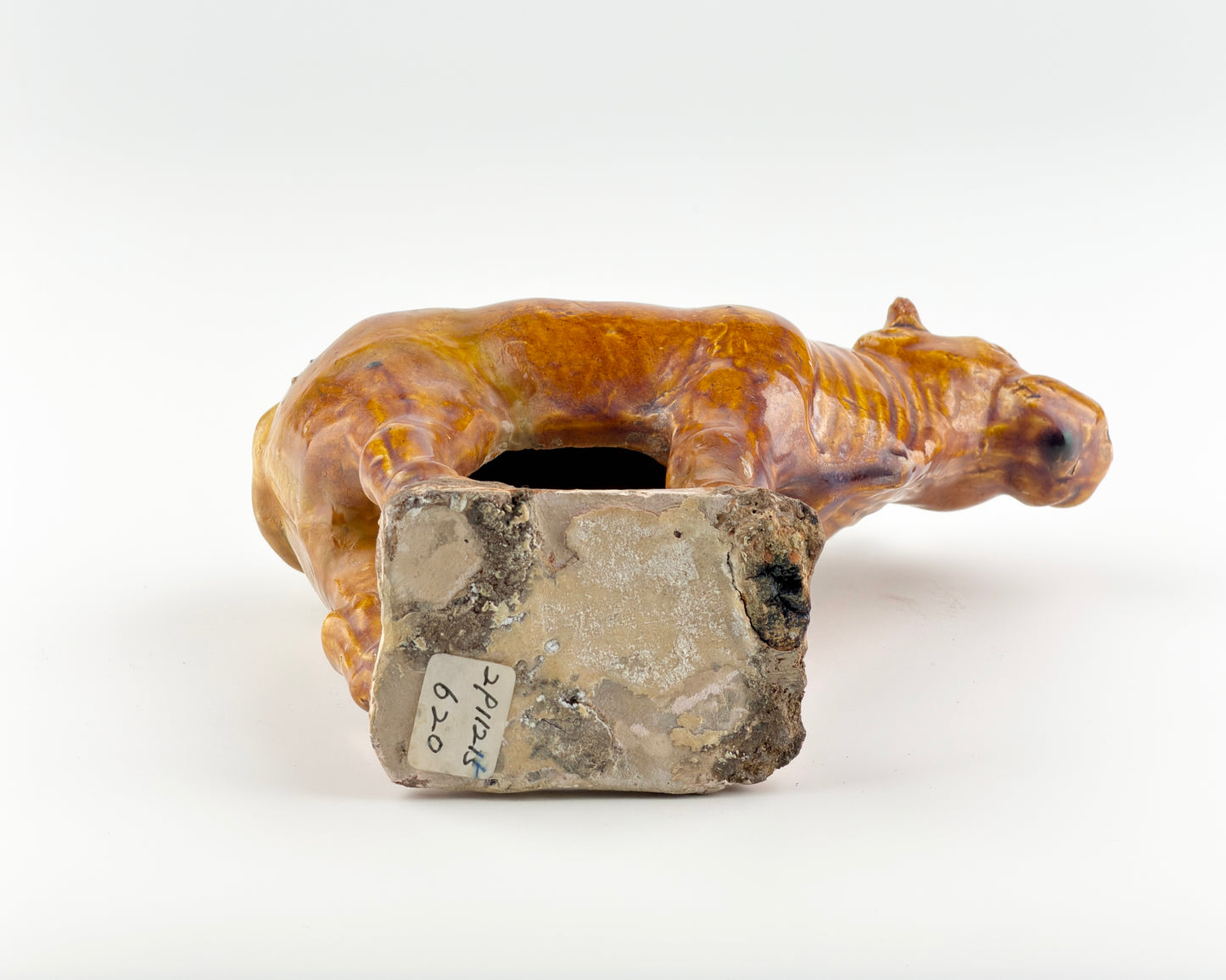 AMBER-GLAZED POTTERY FIGURE OF SACRED BULL, TANG-LIAO DYNASTY (7-12TH CENTURY)
