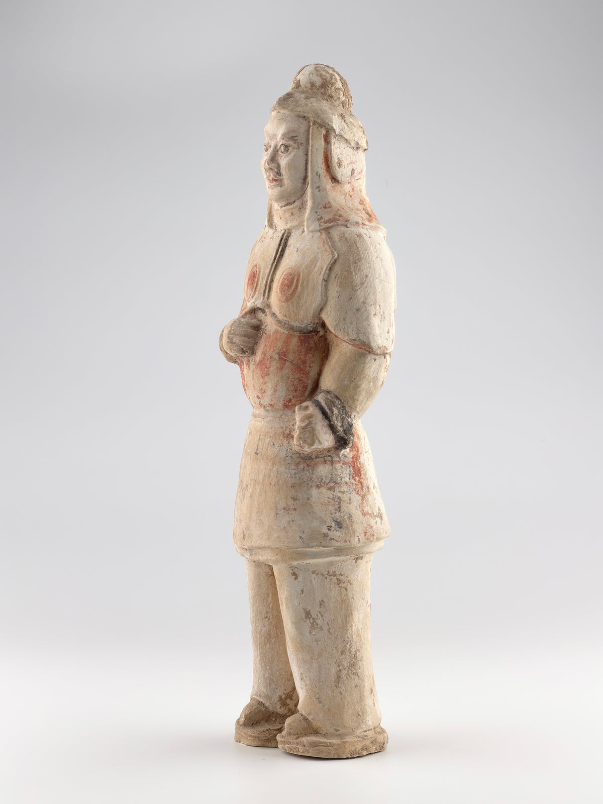 Sui-Tang Dynasty pottery warrior figure with raised arm, clenched fists, layered chest and shoulder armor, and original pigments.