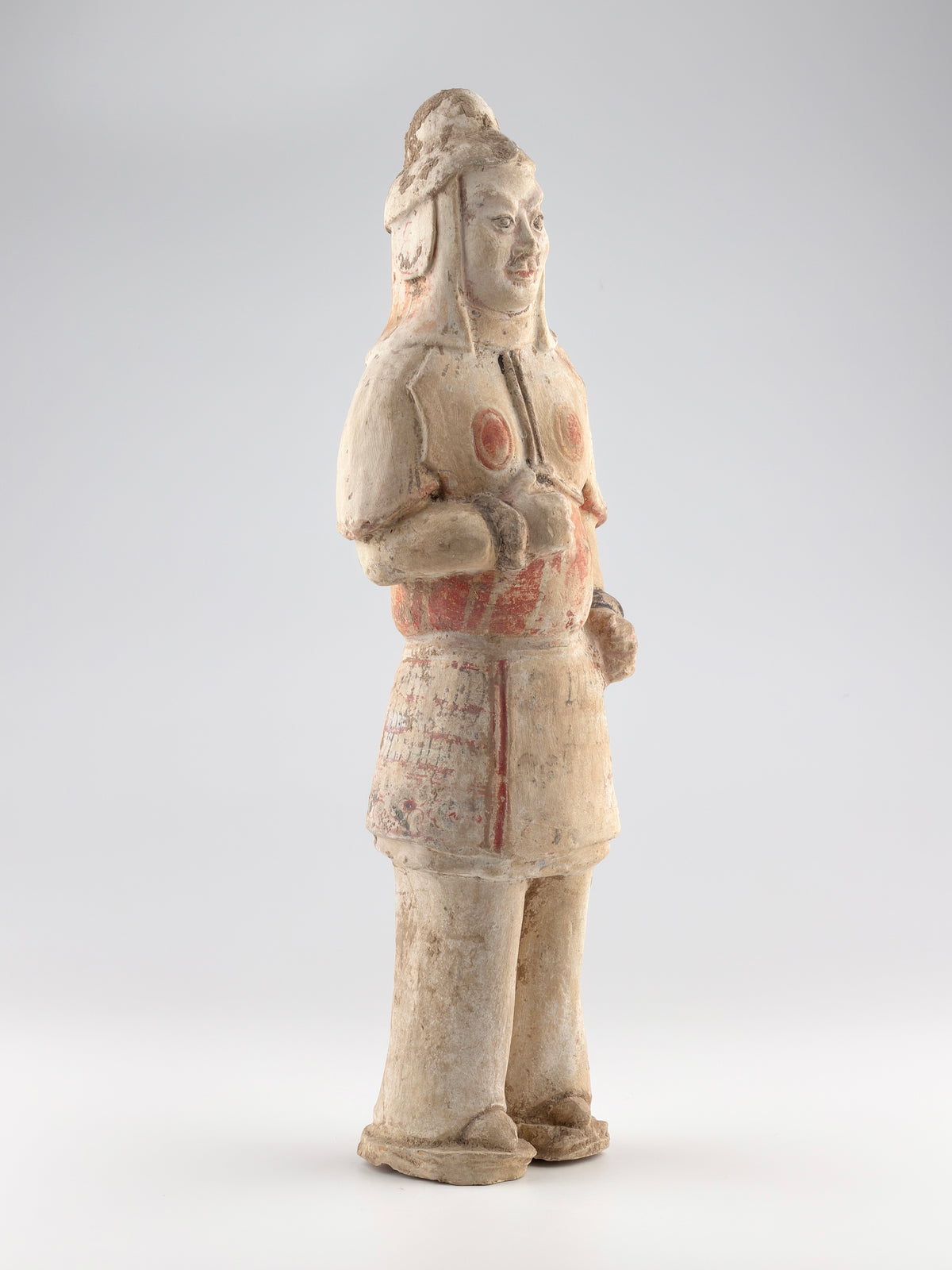 Sui-Tang Dynasty pottery warrior figure with raised arm, clenched fists, layered chest and shoulder armor, and original pigments.