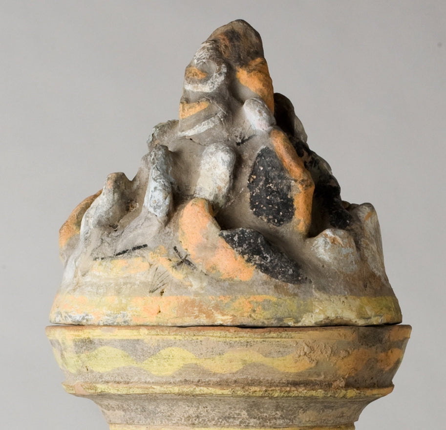 Han Dynasty earthenware pottery jar with mountain-shaped cover, painted yellow, white and black bands, and circular motifs.