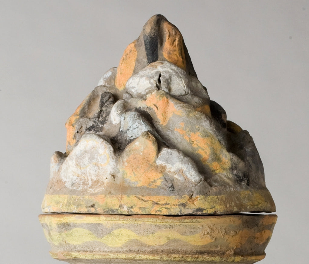 Han Dynasty earthenware pottery jar with mountain-shaped cover, painted yellow, white and black bands, and circular motifs.
