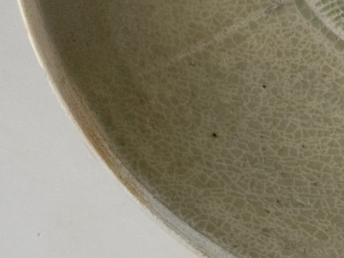 Song Dynasty porcelain bowl with carved twin-fish design, pale blue-white glaze, and low foot.