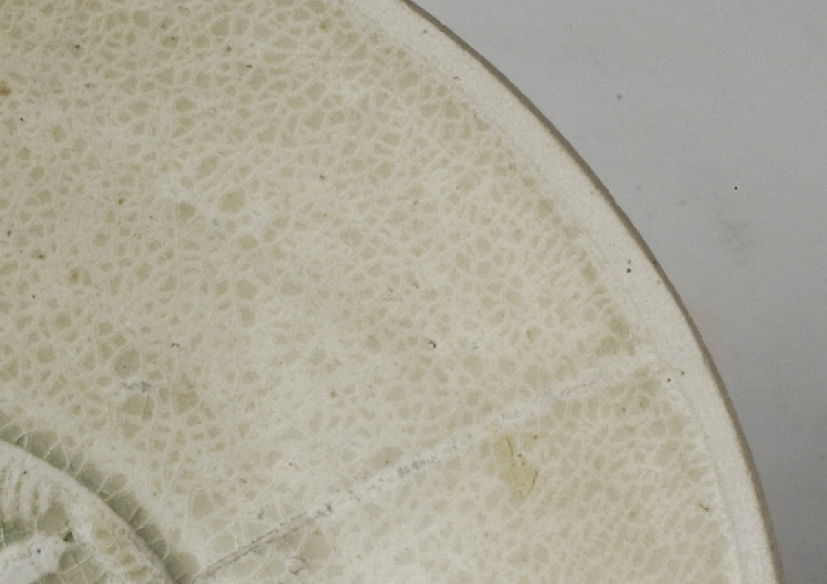 Song Dynasty porcelain bowl with carved twin-fish design, pale blue-white glaze, and low foot.