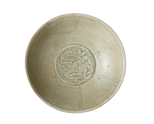 Song Dynasty porcelain bowl with carved twin-fish design, pale blue-white glaze, and low foot.