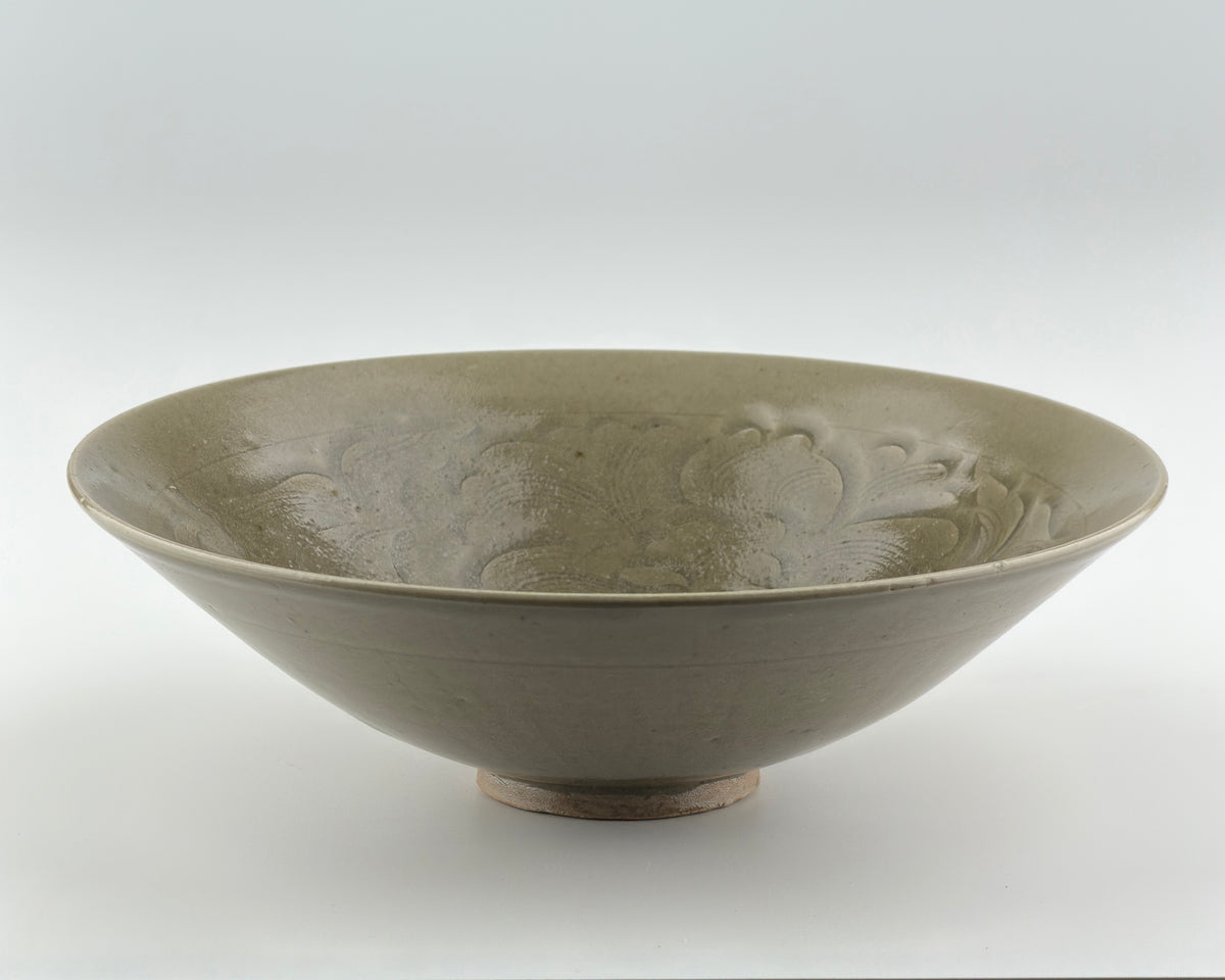 Song Dynasty Yaozhou celadon bowl with carved peony scroll, olive-grey glaze, flared sides, and vertical fluting.