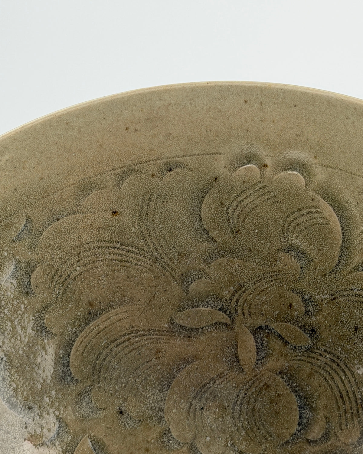 Song Dynasty Yaozhou celadon bowl with carved peony scroll, olive-grey glaze, flared sides, and vertical fluting.
