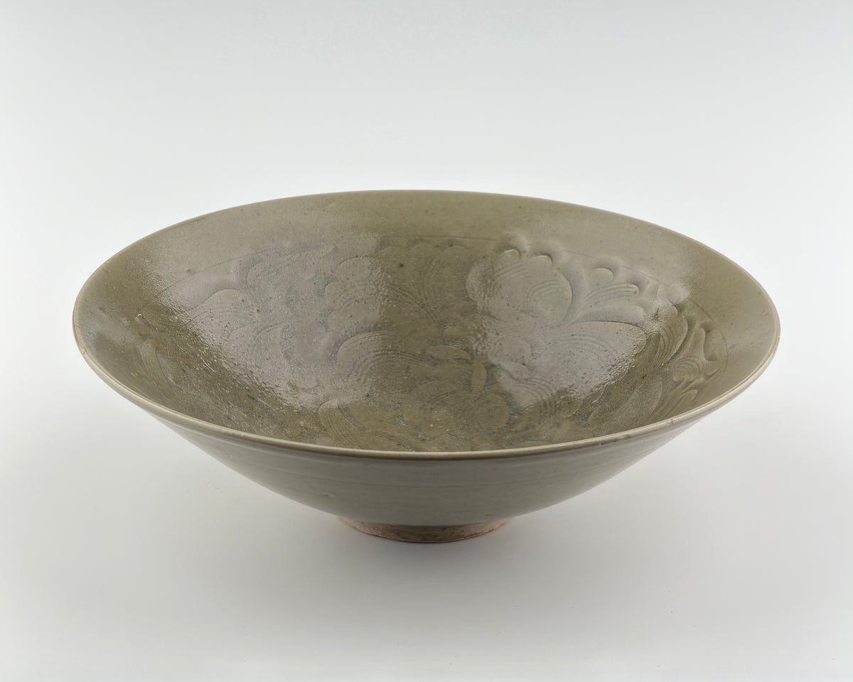 Song Dynasty Yaozhou celadon bowl with carved peony scroll, olive-grey glaze, flared sides, and vertical fluting.