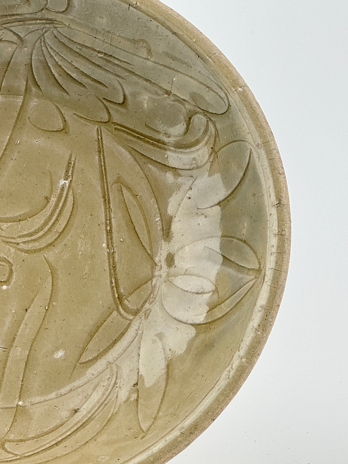 Song Dynasty celadon bowl with incised lotus flower and leaf patterns, soft grayish-green glaze, and fine surface crackling.