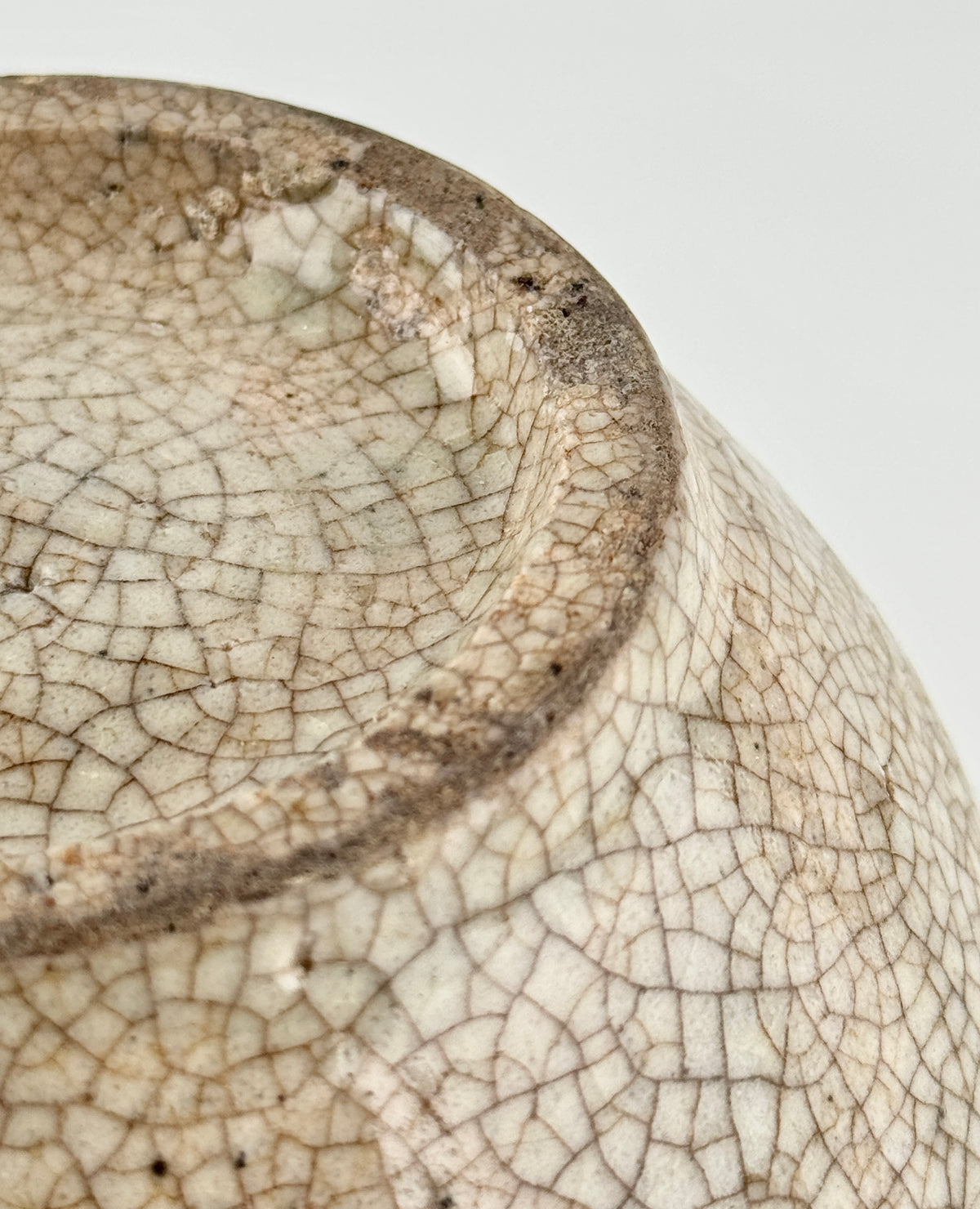 Chinese crackle-glazed ceramic bowl with rounded form, pale grey-yellow glaze, and brown crackle network, Qing or Song Dynasty.