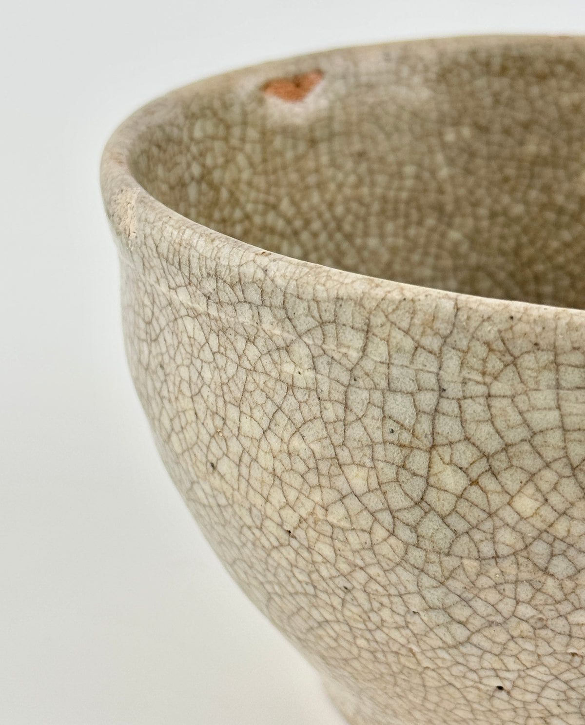 Chinese crackle-glazed ceramic bowl with rounded form, pale grey-yellow glaze, and brown crackle network, Qing or Song Dynasty.