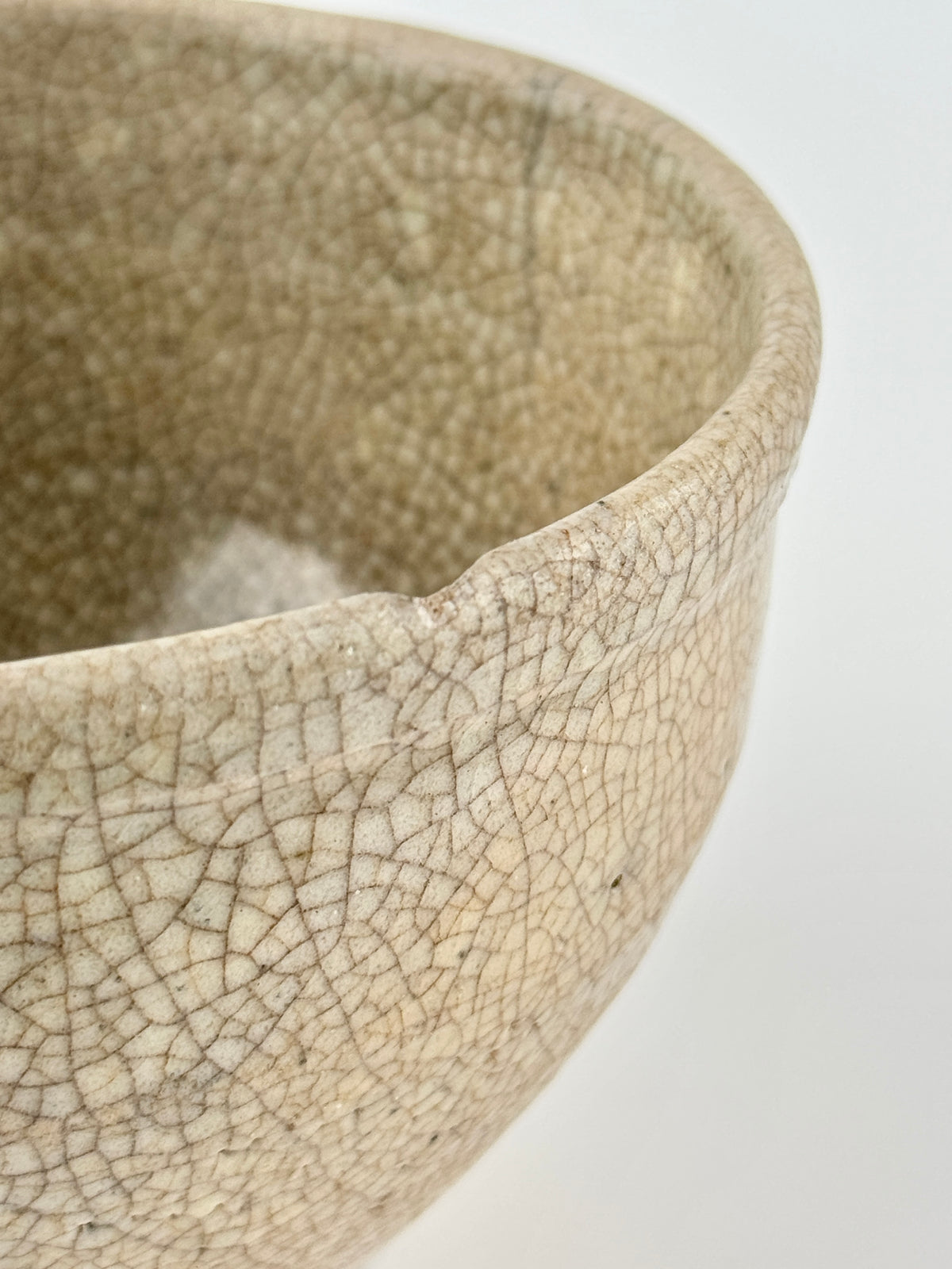 Chinese crackle-glazed ceramic bowl with rounded form, pale grey-yellow glaze, and brown crackle network, Qing or Song Dynasty.