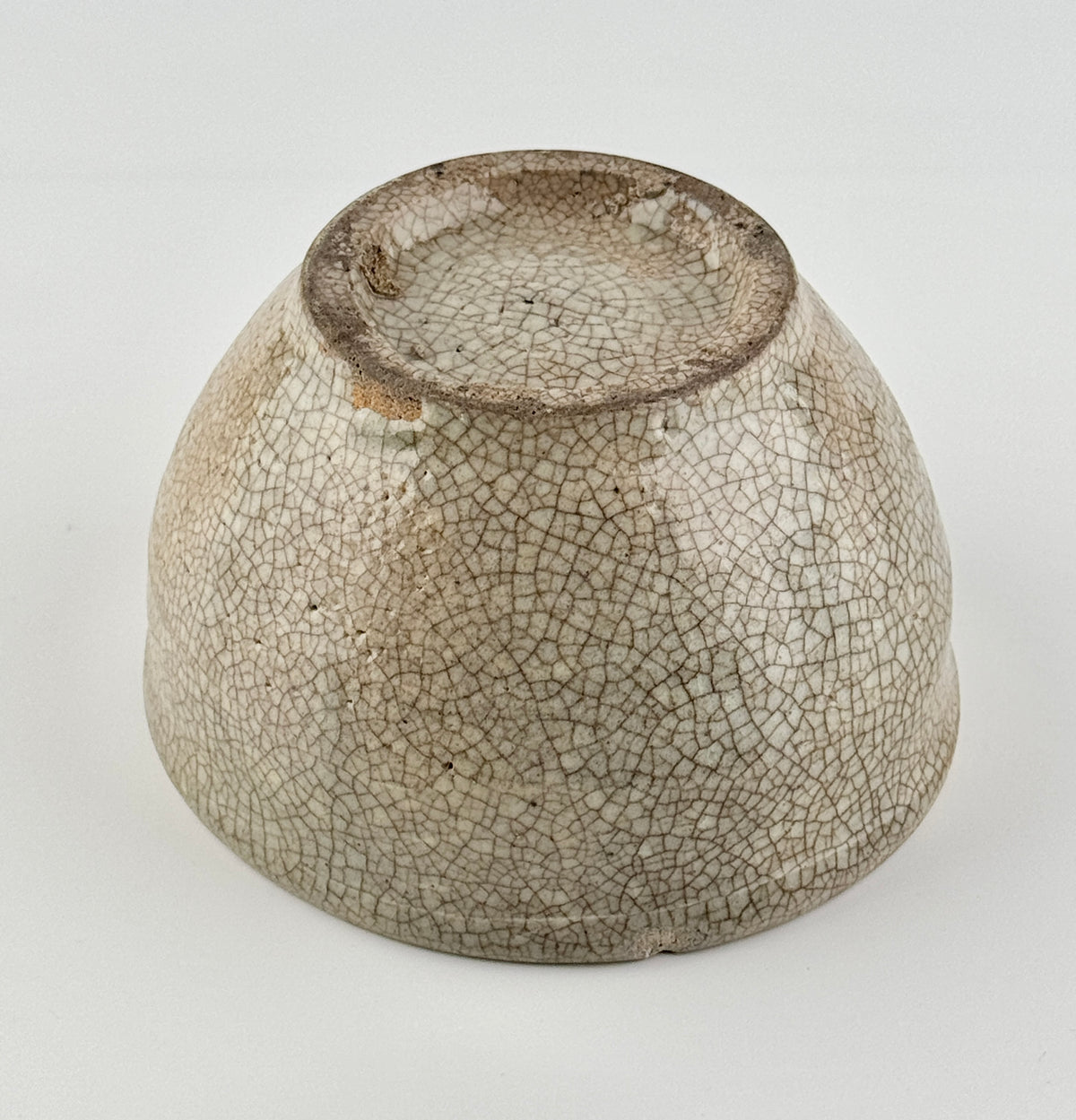 Chinese crackle-glazed ceramic bowl with rounded form, pale grey-yellow glaze, and brown crackle network, Qing or Song Dynasty.