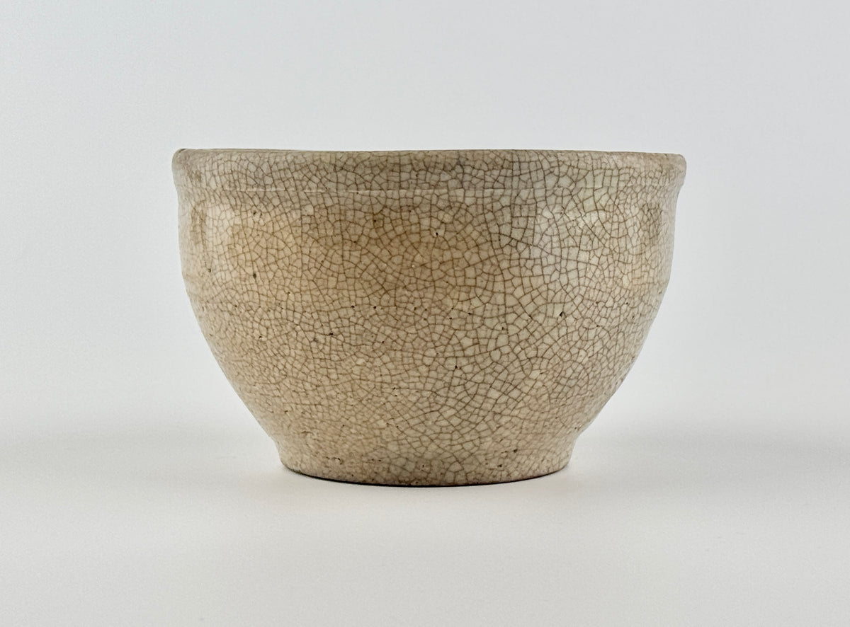 Chinese crackle-glazed ceramic bowl with rounded form, pale grey-yellow glaze, and brown crackle network, Qing or Song Dynasty.