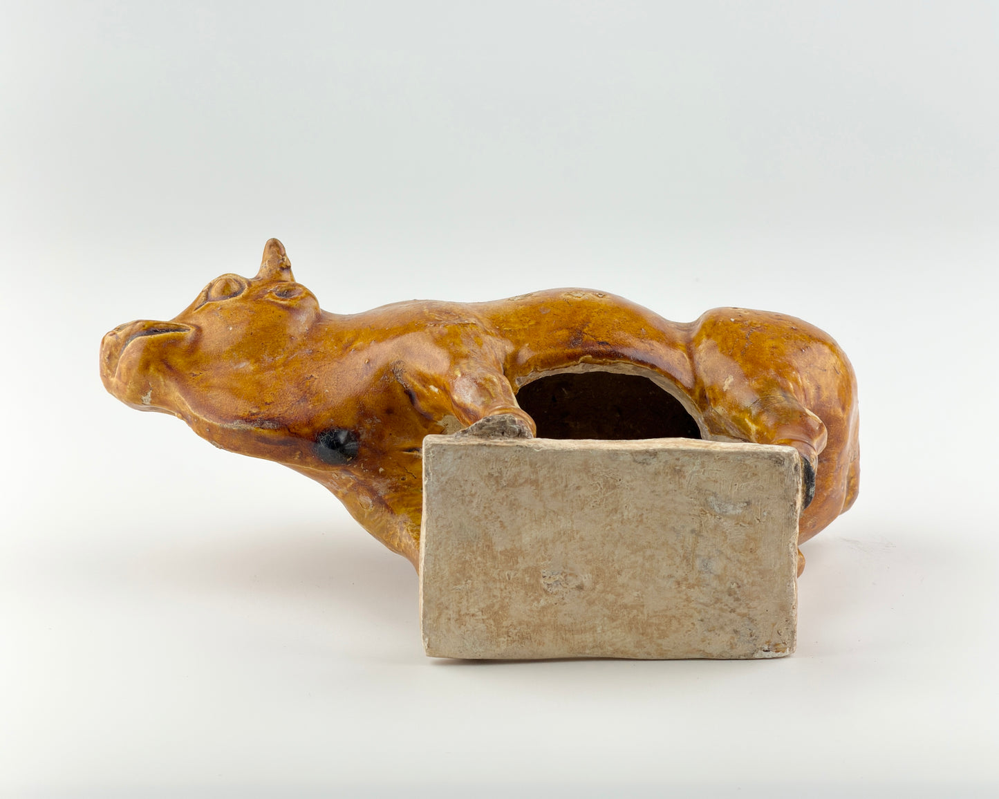 AMBER-GLAZED POTTERY FIGURE OF SACRED BULL, TANG-LIAO DYNASTY (7-12TH CENTURY)