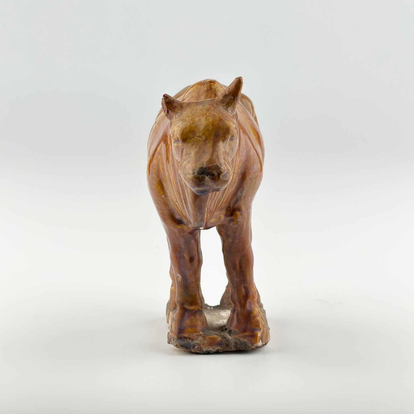 AMBER-GLAZED POTTERY FIGURE OF SACRED BULL, TANG-LIAO DYNASTY (7-12TH CENTURY)
