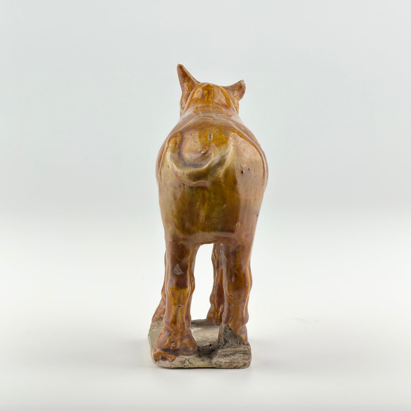 AMBER-GLAZED POTTERY FIGURE OF SACRED BULL, TANG-LIAO DYNASTY (7-12TH CENTURY)
