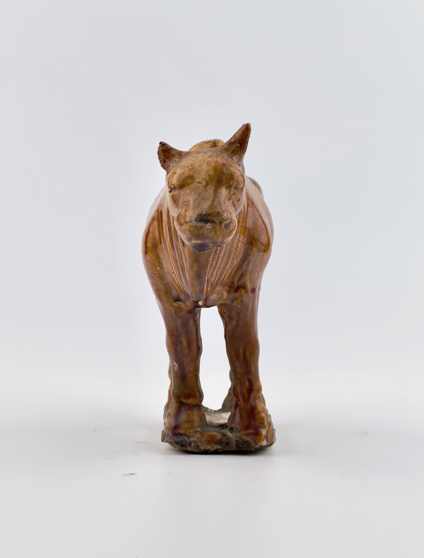 AMBER-GLAZED POTTERY FIGURE OF SACRED BULL, TANG-LIAO DYNASTY (7-12TH CENTURY)