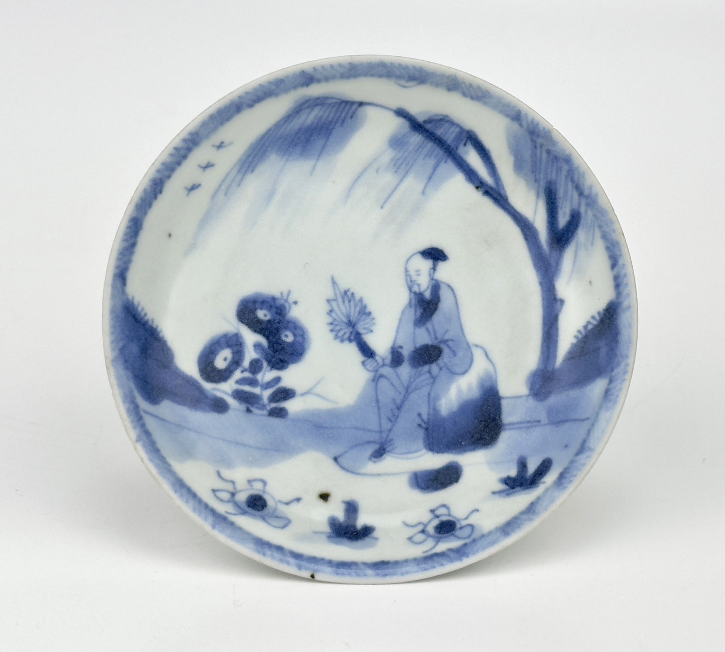 SCHOLARLY REPOSE BLUE AND WHITE SAUCER CIRCA 1725, QING DYNASTY, YONGZHENG REIGN