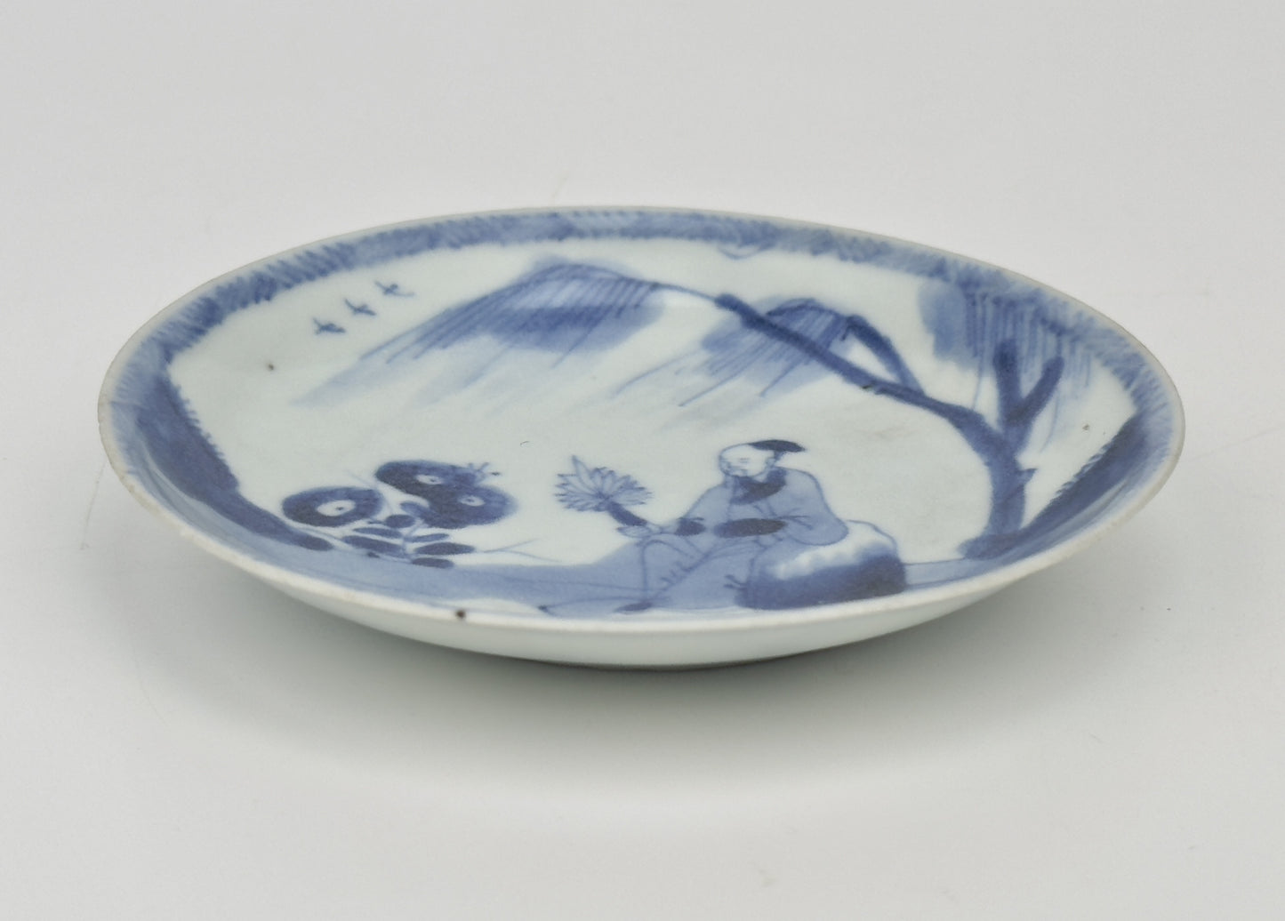 SCHOLARLY REPOSE BLUE AND WHITE SAUCER CIRCA 1725, QING DYNASTY, YONGZHENG REIGN