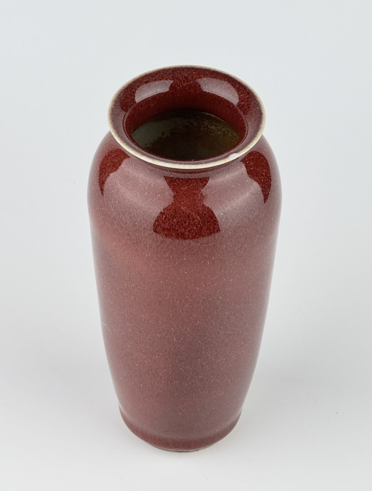 Qing Dynasty Langyao copper-red glazed porcelain vase with glossy purplish-red glaze and elegant balanced form.