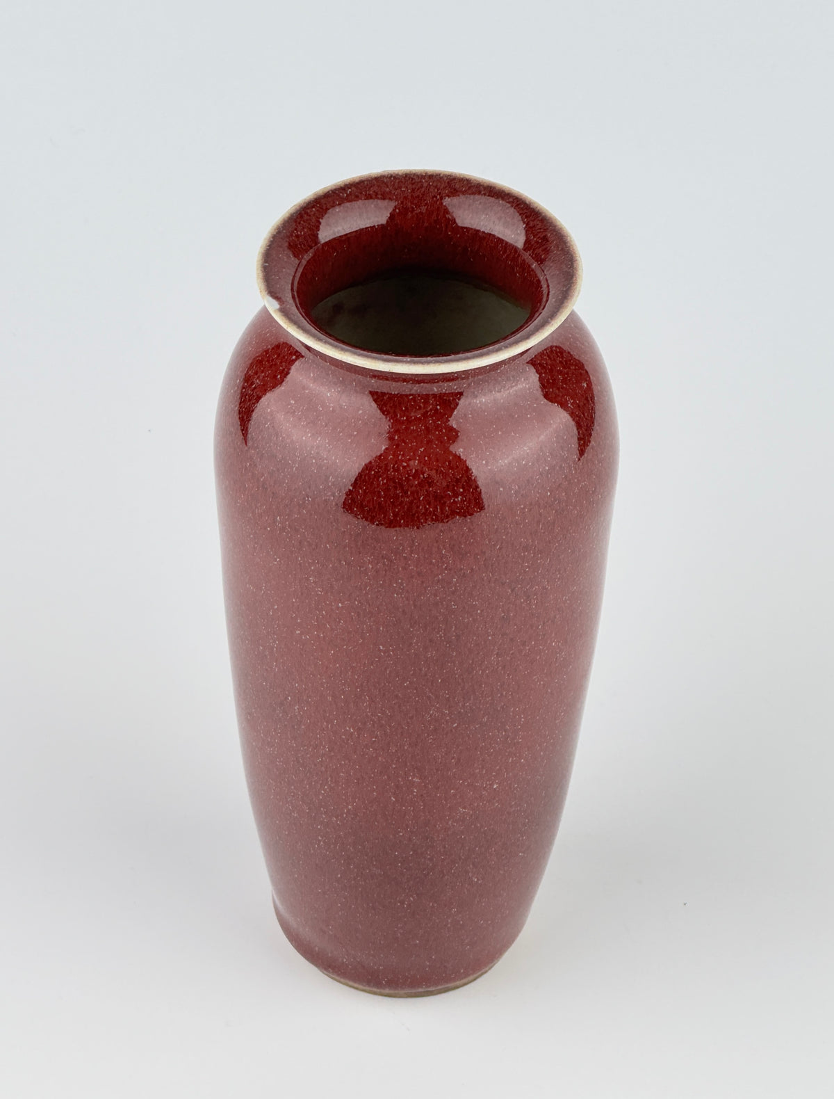 Qing Dynasty Langyao copper-red glazed porcelain vase with glossy purplish-red glaze and elegant balanced form.