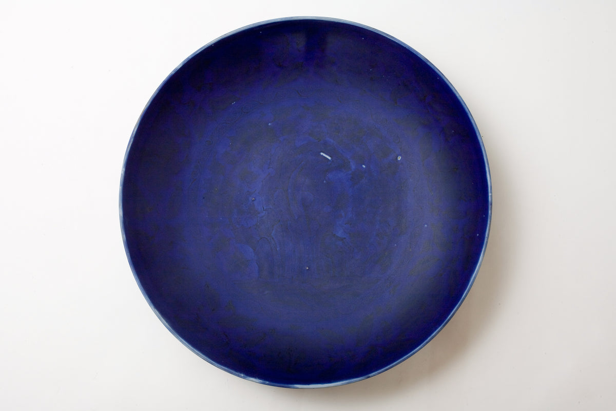Large Qing Dynasty cobalt-blue glazed porcelain dish with rockwork and floral motifs, shipwreck-recovered, Kangxi-Yongzheng period.