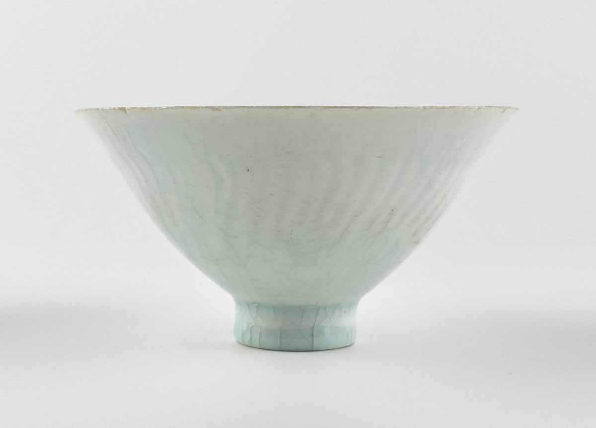 Southern Song-Yuan Qingbai porcelain conical bowl with pale bluish glaze, lotus-petal relief, and natural crackling.