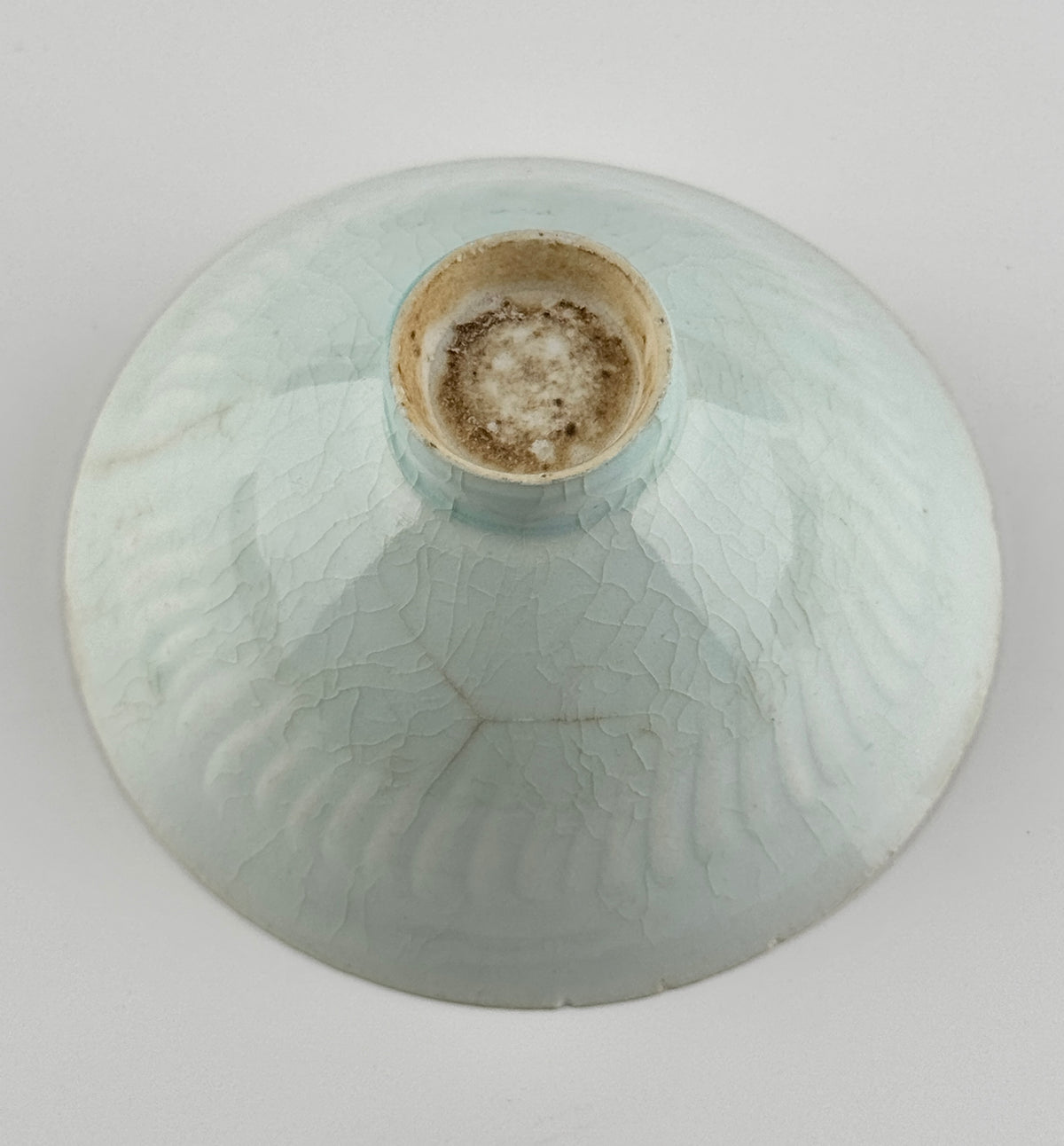 Southern Song-Yuan Qingbai porcelain conical bowl with pale bluish glaze, lotus-petal relief, and natural crackling.