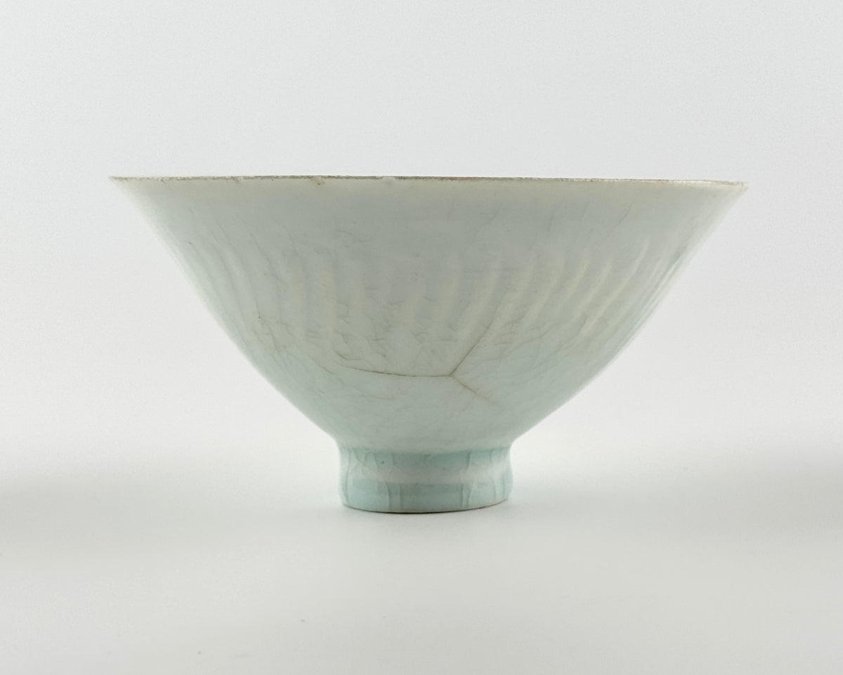 Southern Song-Yuan Qingbai porcelain conical bowl with pale bluish glaze, lotus-petal relief, and natural crackling.