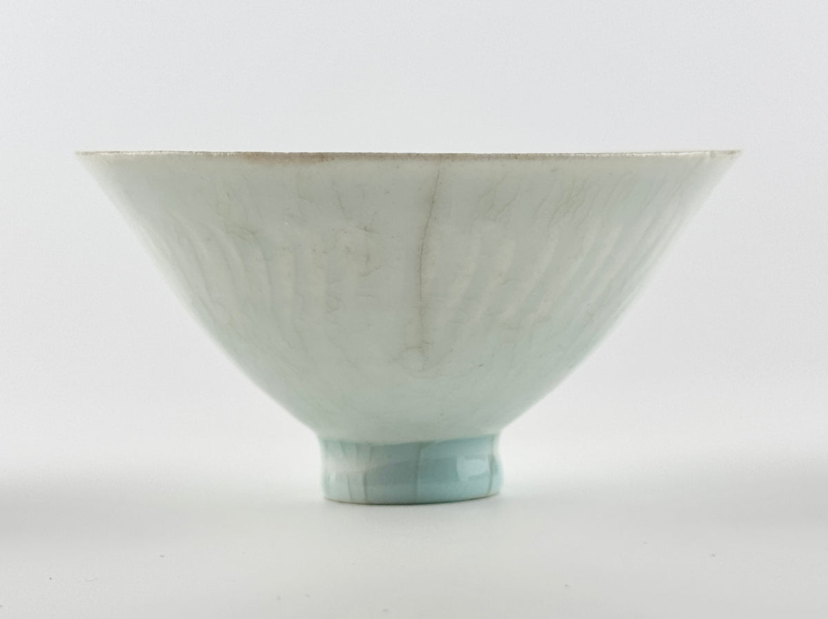 Southern Song-Yuan Qingbai porcelain conical bowl with pale bluish glaze, lotus-petal relief, and natural crackling.
