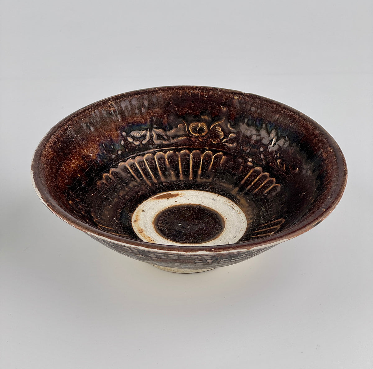 Pair of 15th-century Vietnamese Annamese stoneware bowls with carved floral decoration and olive-green to iron-brown glaze.