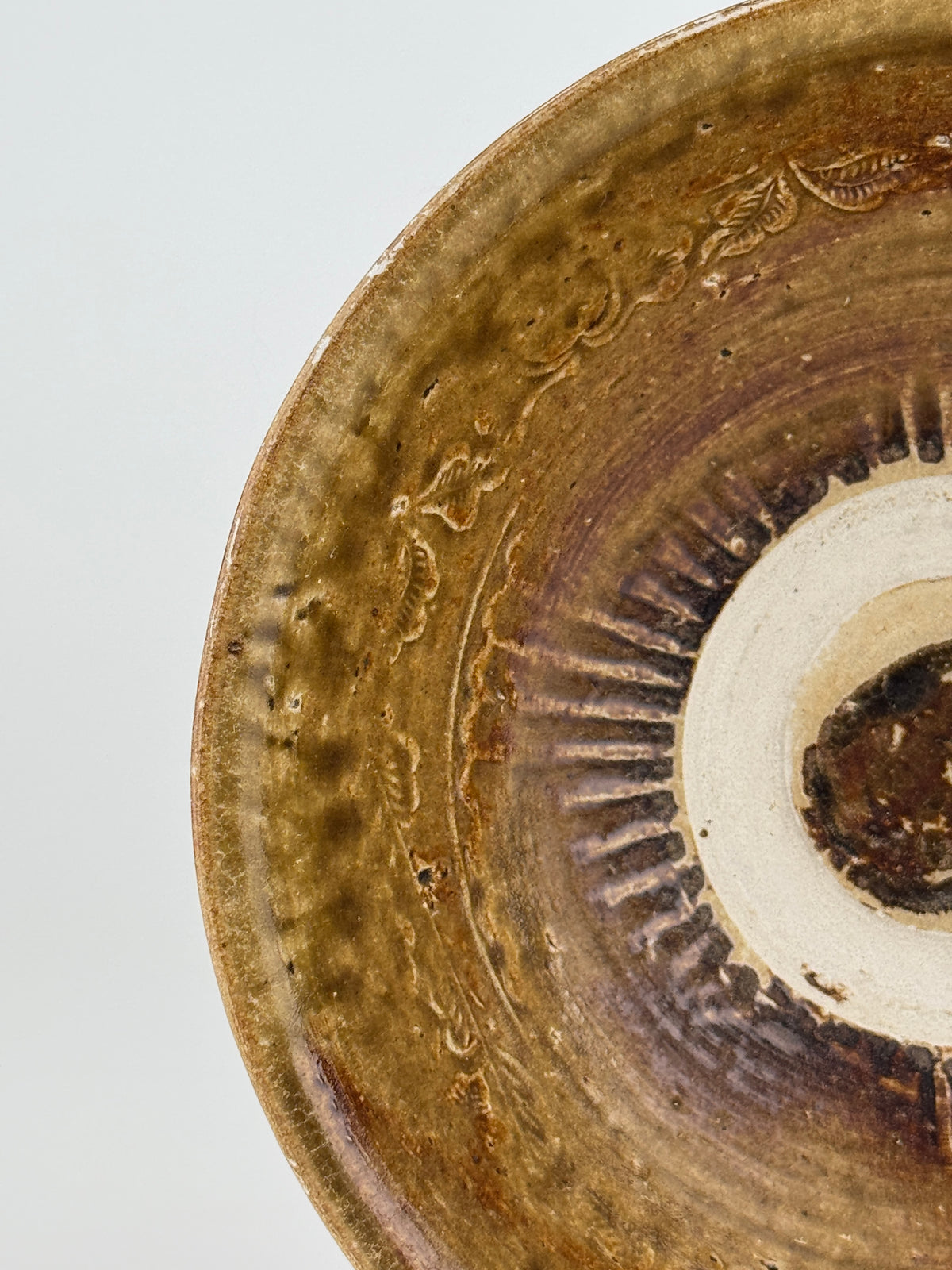 Pair of 15th-century Vietnamese Annamese stoneware bowls with carved floral decoration and olive-green to iron-brown glaze.