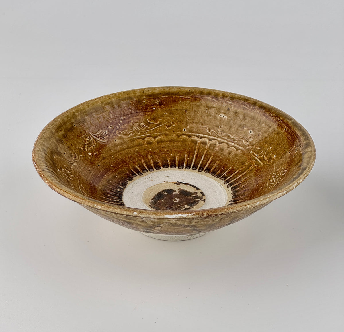 Pair of 15th-century Vietnamese Annamese stoneware bowls with carved floral decoration and olive-green to iron-brown glaze.