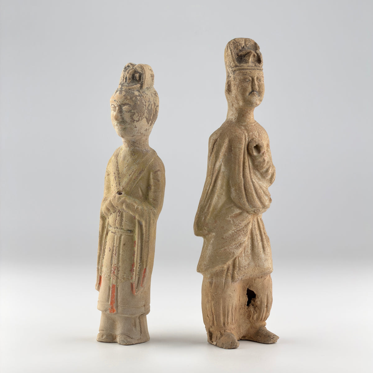 Sui-Tang Dynasty pair of straw-glazed pottery court figures with traditional robes, official cap, and red pigment traces.