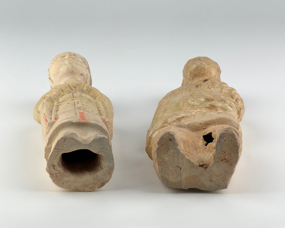 Sui-Tang Dynasty pair of straw-glazed pottery court figures with traditional robes, official cap, and red pigment traces.