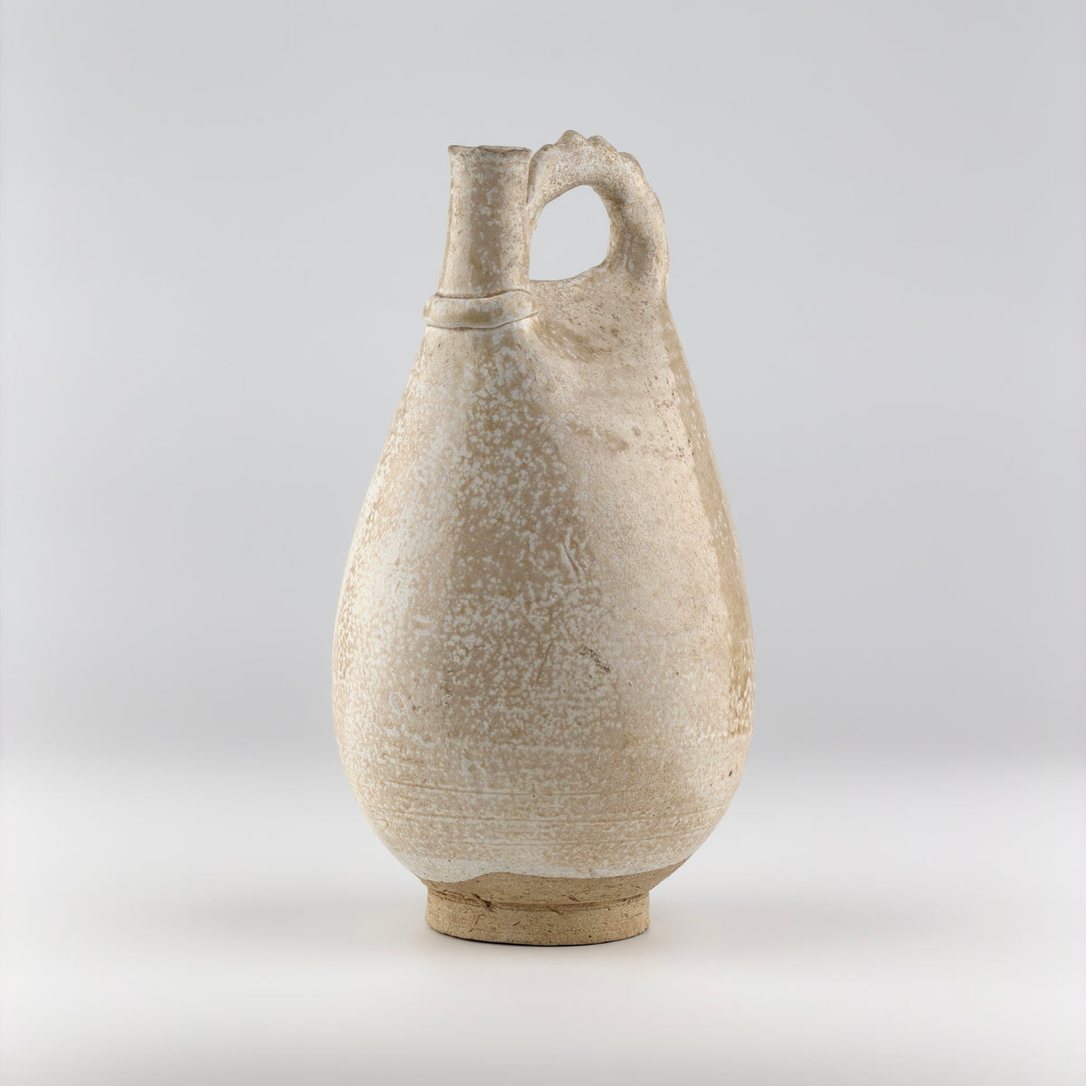 Liao Dynasty white-glazed chicken-comb ewer with a rounded body, inspired by nomadic leather water flasks.