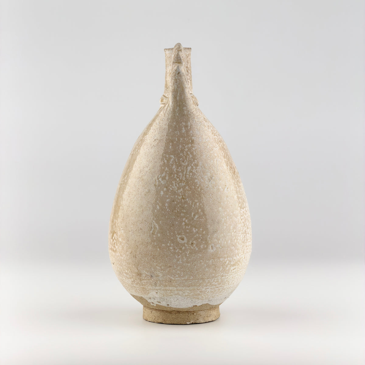 Liao Dynasty white-glazed chicken-comb ewer with a rounded body, inspired by nomadic leather water flasks.