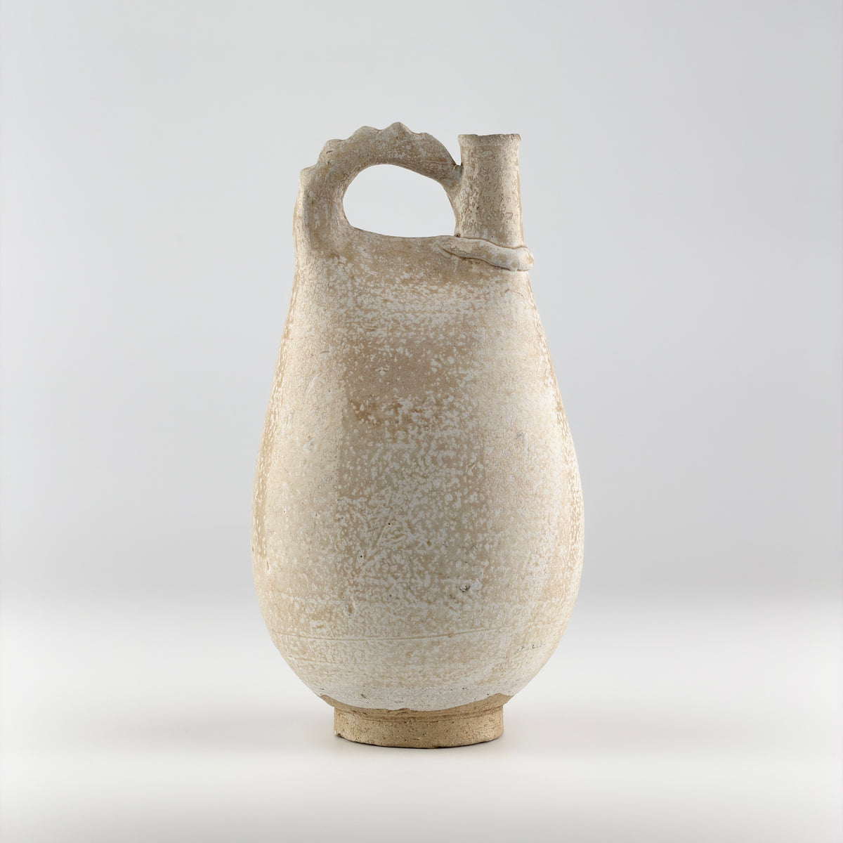 Liao Dynasty white-glazed chicken-comb ewer with a rounded body, inspired by nomadic leather water flasks.